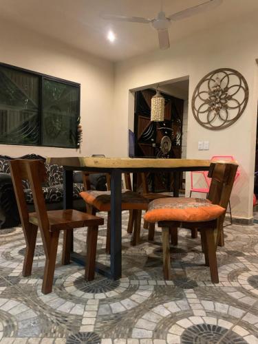 a wooden table and chairs in a living room at Casa Delfín Tulum in Macario Gomez