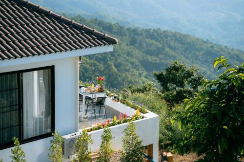 uma casa com uma mesa e vista para uma montanha em Above the clouds - Doi mae mon 