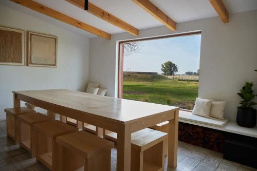 ein Esszimmer mit einem Tisch und einem großen Fenster in der Unterkunft Hestia At San Antonio De Areco I Estancia Paraso in San Antonio de Areco