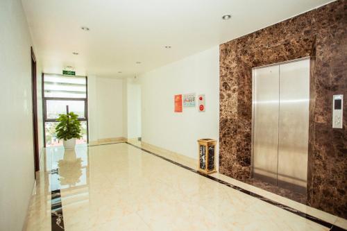 an empty lobby with a elevator and a potted plant at Royal ANAN Hotel in Ninh Binh