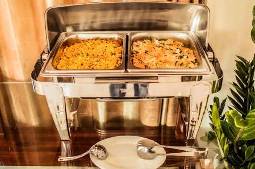 two trays of casseroles sitting on top of a food processor at Royal ANAN Hotel in Ninh Binh
