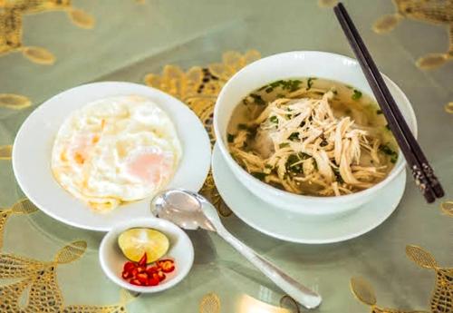 a bowl of soup and a bowl of food on a table at Royal ANAN Hotel in Ninh Binh