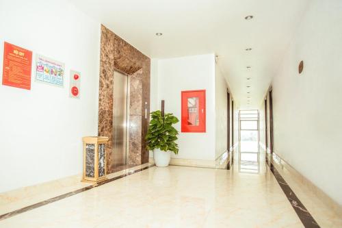 a hallway with white walls and a potted plant at Royal ANAN Hotel in Ninh Binh