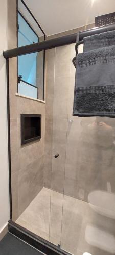 a bathroom with a glass shower with a toilet at Loft Dream Rest II in Teresópolis