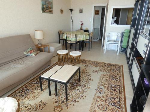 un salon avec un canapé et une table dans l'établissement Studio cabine bord de mer avec balcon et parking privé - FR-1-323-421, à Saint-Jean-de-Monts