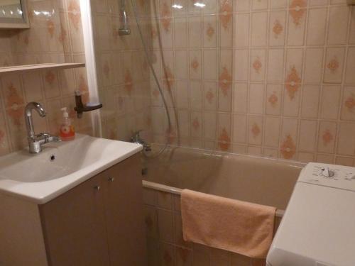 une salle de bain avec un lavabo et une baignoire dans l'établissement Studio cabine bord de mer avec balcon et parking privé - FR-1-323-421, à Saint-Jean-de-Monts