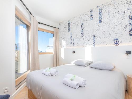 Un dormitorio con una cama blanca con toallas. en Appartement Avoriaz, 5 pièces, 8 personnes - FR-1-314-241 en Morzine