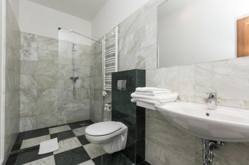 a bathroom with a sink and a toilet and a shower at Grottger Luxury Boutique Hotel City in Krakow