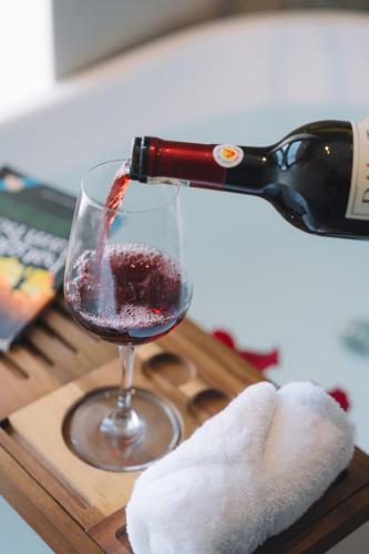 a bottle of wine being poured into a wine glass at Canary Dalat Hotel in Da Lat
