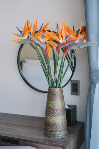 a vase filled with colorful paper flowers on a table at Canary Dalat Hotel in Da Lat