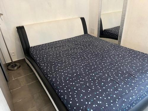 Ce lit se trouve dans un dortoir doté d'un drap bleu et blanc. dans l'établissement Appartement T2 Climatisé au Cœur du Cap d'Agde, proche Port et Plages, 4 Personnes - FR-1-749-41, au Cap d'Agde