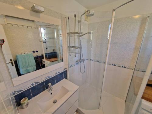 une salle de bain blanche avec une douche et un lavabo dans l'établissement Beau T2 en front de mer avec clim, parking, animaux admis - FR-1-100-327, à Cavalaire-sur-Mer