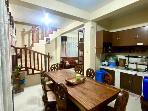 Una cocina y un comedor con mesa y sillas de madera. en Backpackers hostel and transient house, en Nangalisan