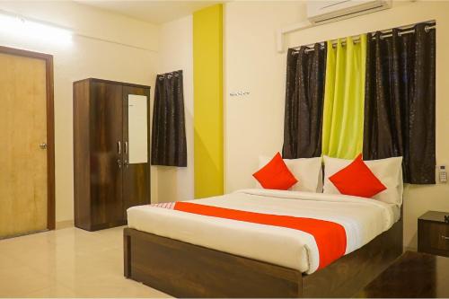 a bedroom with a large bed with red pillows at Super Collection O D'Villa in Pune