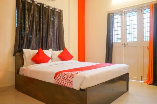 a bedroom with a bed with red pillows at Super Collection O D'Villa in Pune