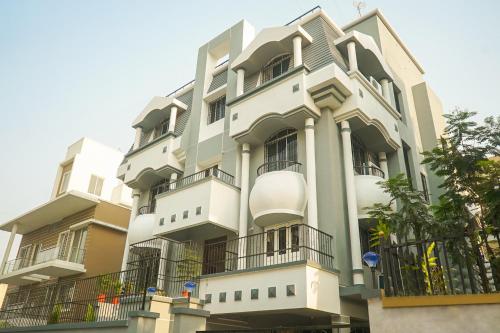 Biały budynek z balkonami na boku w obiekcie Super Collection O D'Villa w mieście Pune