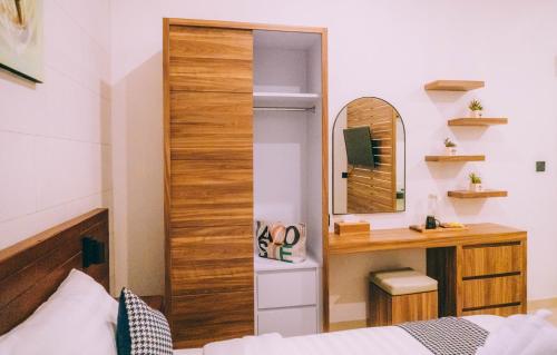 a bedroom with a bed and a mirror at Budha Manis Villa in Kerobokan