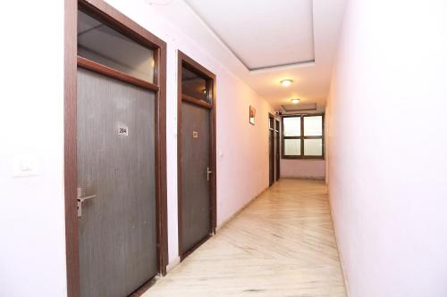 an empty hallway with two doors and a wooden floor at OYO Hotel Kanha Palace in Kota