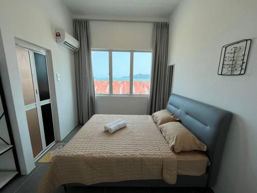 a bedroom with a bed and a large window at Level 4 Simfoni Beliza in Kuah