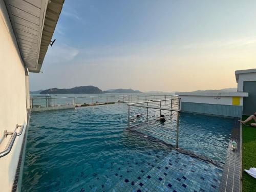 a swimming pool with a view of the water at Level 4 Simfoni Beliza in Kuah