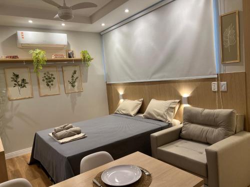 リオデジャネイロにあるMARAVILHOSO APARTAMENTO NO LEBLONのベッド1台、椅子、テーブルが備わる小さな客室です。