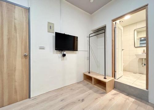 a bathroom with a tv on the wall next to a door at Yan Bin Hotel in Tainan