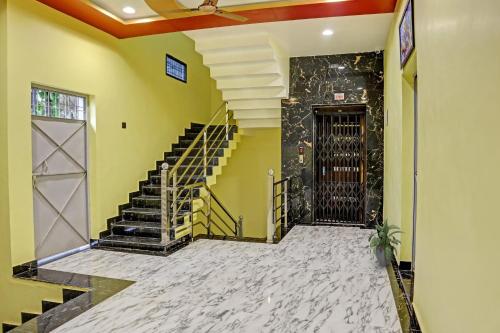 een hal met een trap en een zwarte deur bij Flagship Hotel Jnk in Bilāspur