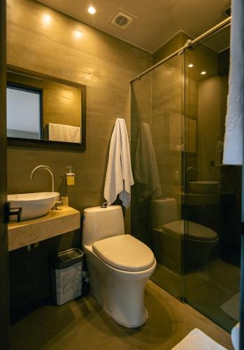 a bathroom with a toilet and a sink and a shower at Balmoral Plaza Hotel in Pereira