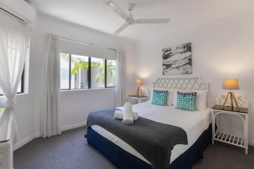 a bedroom with a large bed and a window at Unit 15 @ Tropical Reef: 2 mins to Four Mile Beach in Port Douglas