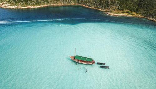 una barca in mezzo a un grande bacino d'acqua di Janelas para o mar ad Arraial do Cabo