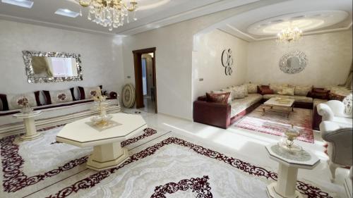 a large living room with a couch and a table at appartement luxe Mandar Jamil in Tétouan