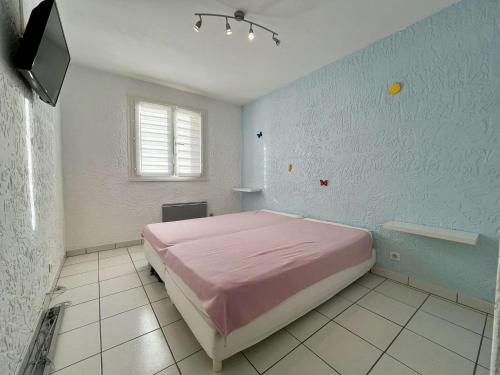 - une chambre avec un lit rose et une télévision dans l'établissement Appartement climatisé à Cavalaire-sur-Mer, 2 pièces, parking privé, proche plages et commerces - FR-1-226B-181, à Cavalaire-sur-Mer