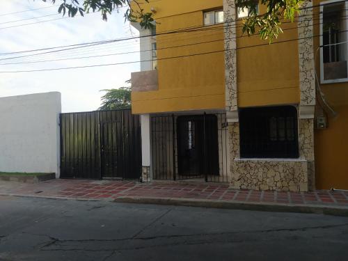 un bâtiment jaune avec une porte noire à côté d'une rue dans l'établissement Casa Mar Riohacha, à Ríohacha