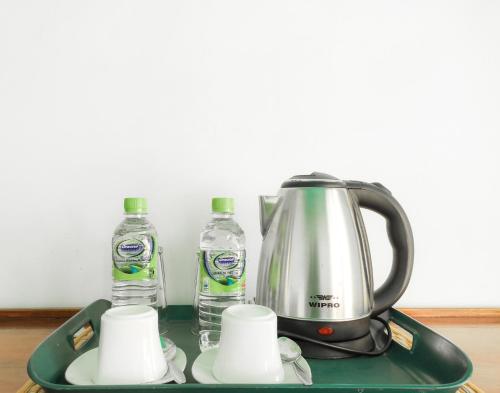 a tea kettle and two bottles of water on a tray at The Pearl Homestay in Nugatalawa
