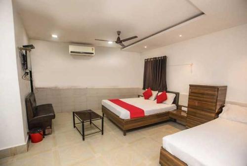 a bedroom with a bed and a chair in a room at OYO Flagship Sea land lodging & Restuarant in Mumbai