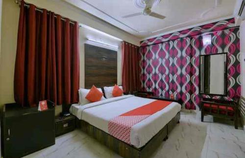 a bedroom with a bed and red curtains at HOTEL SKY HEIGHTS PALACE in Jaipur