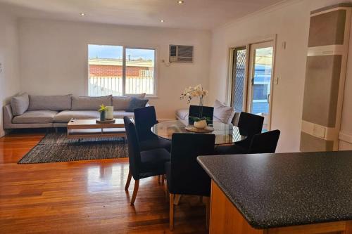 a living room with a table and chairs and a couch at Tranquil and cosy guest house in Oakleigh East