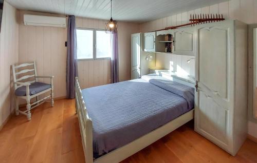 une chambre avec un lit et une chaise dedans dans l'établissement Stunning Home In Mios, à Mios