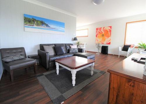 a living room with a couch and a coffee table at Breakaway, 11 Scott Street in Crescent Head
