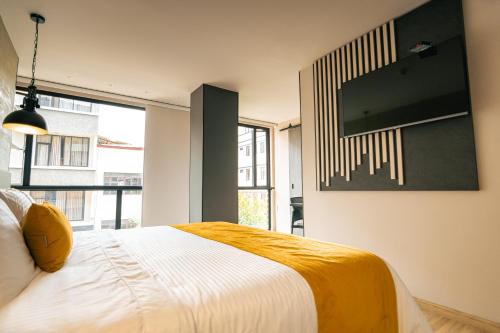 a bedroom with a bed and a tv on the wall at Balmoral Plaza Hotel in Pereira