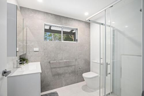 een badkamer met een douche, een toilet en een wastafel bij The Palm in Mylestom