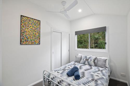 a white bedroom with a bed and a window at The Palm in Mylestom