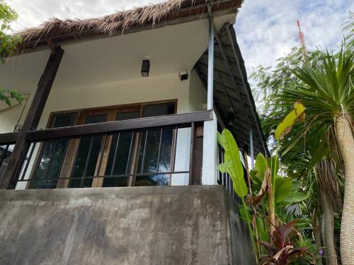 a house with glass doors and palm trees at Pier26 Bali Homestay in Nusa Dua