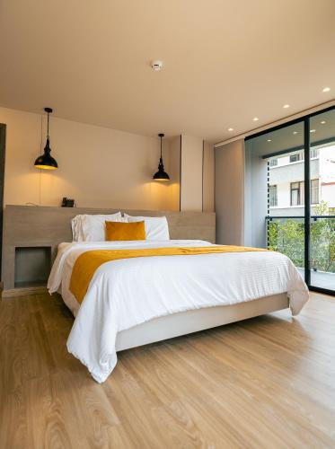 a bedroom with a large bed with white and orange sheets at Balmoral Plaza Hotel in Pereira