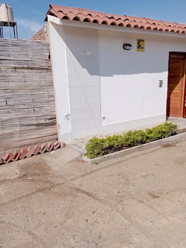 una porta bianca del garage di fronte a una casa di La Silvita - Casa de playa a Los Órganos