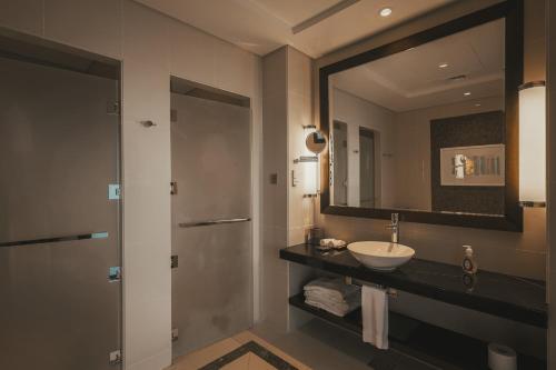a bathroom with a sink and a mirror at Voyage Two Bedroom In Fairmont in Abu Dhabi