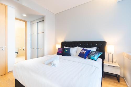 a bedroom with a large bed with white sheets and pillows at PineTree Puteri Harbour by RR JBcity in Nusajaya