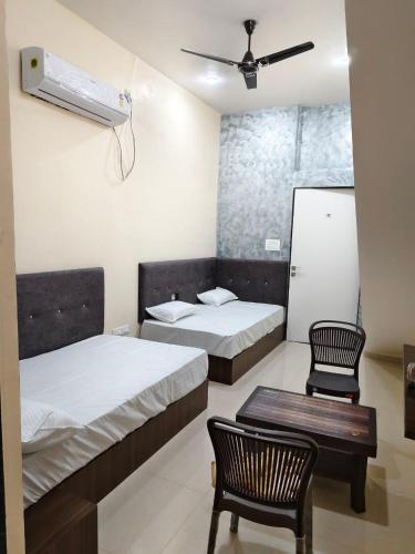 a hotel room with two beds and a chair at Jawai Rock Hotel in Sheoganj