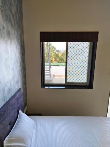 a bedroom with a bed and a window at Jawai Rock Hotel in Sheoganj