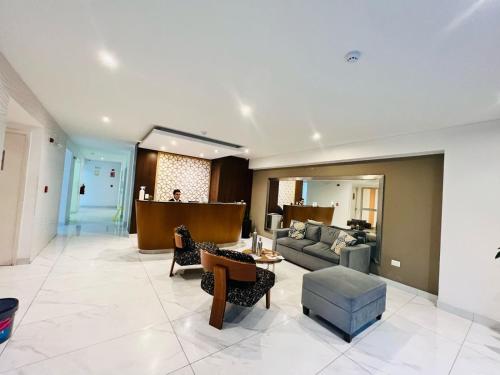 a large living room with a couch and chairs at Habitaciones privadas con vista al parque castilla in Lima